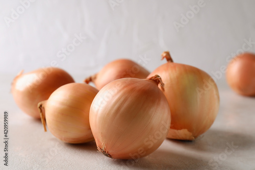 Fresh ripe onion on white textured background