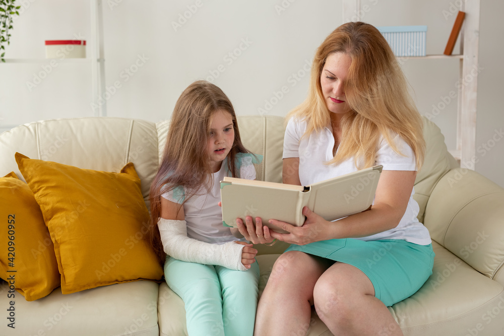 Child with broken arm and gypsum spend time at home with mother. Childhood illnesses, a positive outlook and recovery. Child with broken arm and gypsum spend time at home with mother. Childhood illnesses, a positive outlook and recovery.