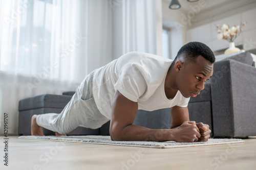 African american guy in white clothes doing morning exercises