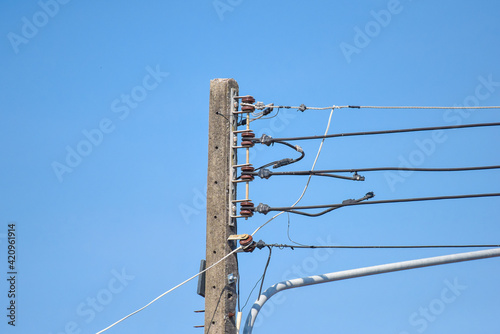top of electric pole with clear blue sky