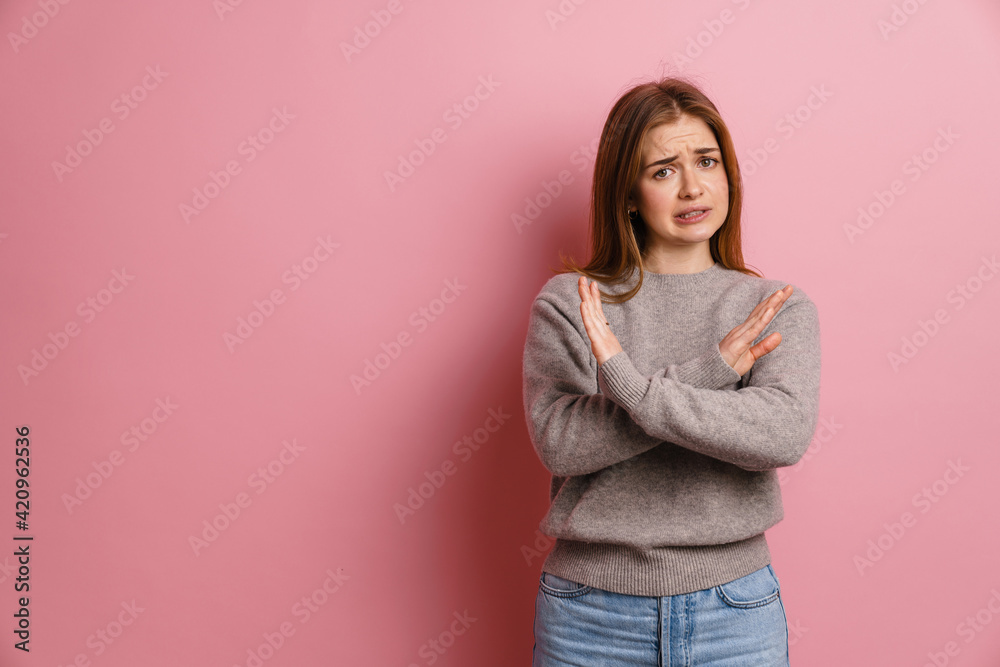 Ginger displeased woman grimacing while showing stop gesture Ginger displeased woman grimacing while showing stop gesture