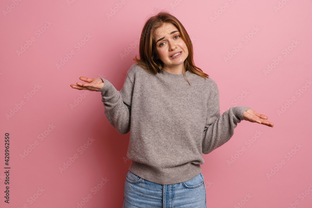 Ginger confused woman looking at camera while holding copyspace Ginger confused woman looking at camera while holding copyspace