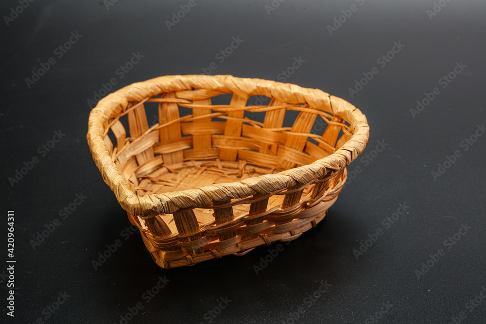 Natural wicker tableware for serving over black Natural wicker tableware for serving over black