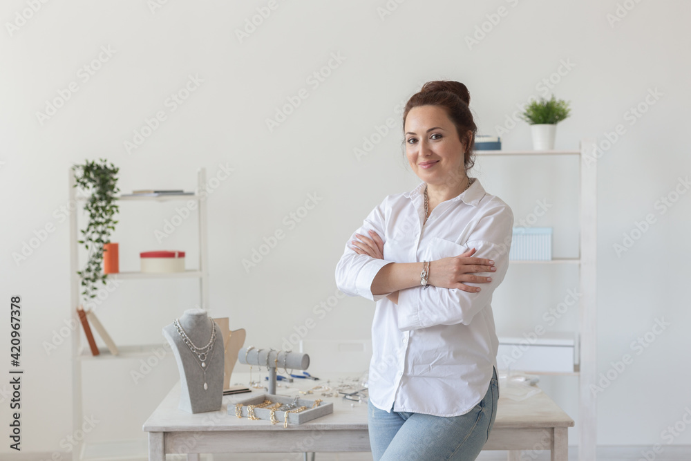 Charming young enthusiastic caucasian woman making beautiful unique costume jewelry while sitting at her desk. Concept of hobby and pleasant work Charming young enthusiastic caucasian woman making beautiful unique costume jewelry while sitting at her desk. Concept of hobby and pleasant work