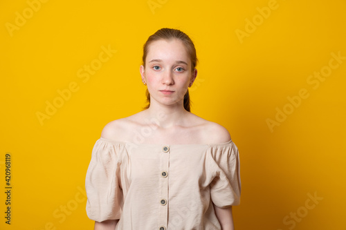 Youth and beauty concept. Portrait of beautiful Caucasian teenage girl wearing her long blonde hair back looking at camera with serious facial expression.