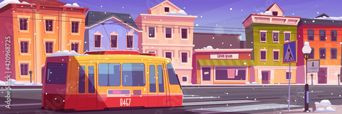 Tram riding on winter retro city street, snow fall