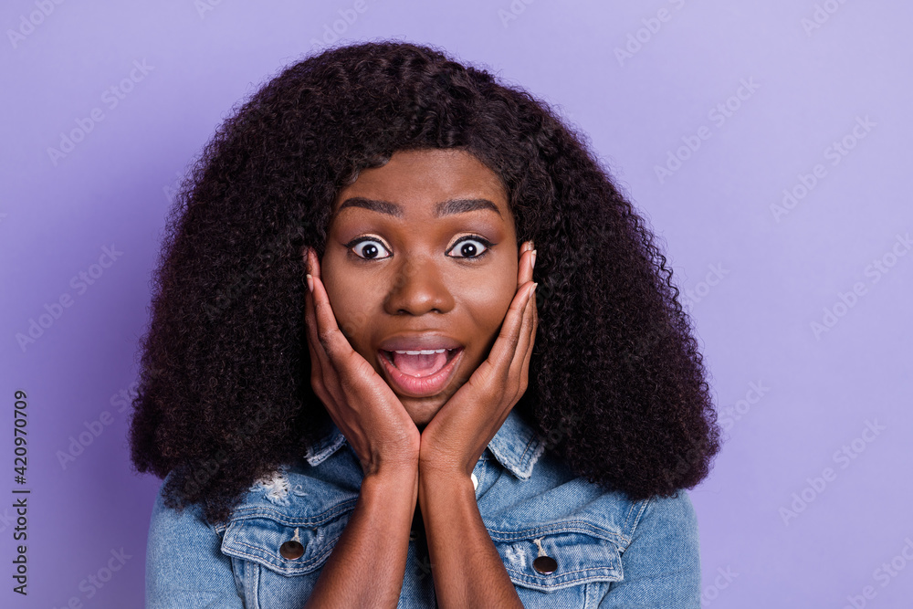 Photo of happy excited amazed shocked afro girl hold hand cheeks see huge sale discount isolated on violet color background Photo of happy excited amazed shocked afro girl hold hand cheeks see huge sale discount isolated on violet color background
