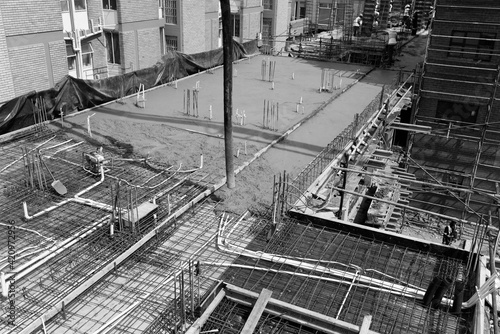 Construction site of multi-storey building with concrete slabs and columns. Men at work .