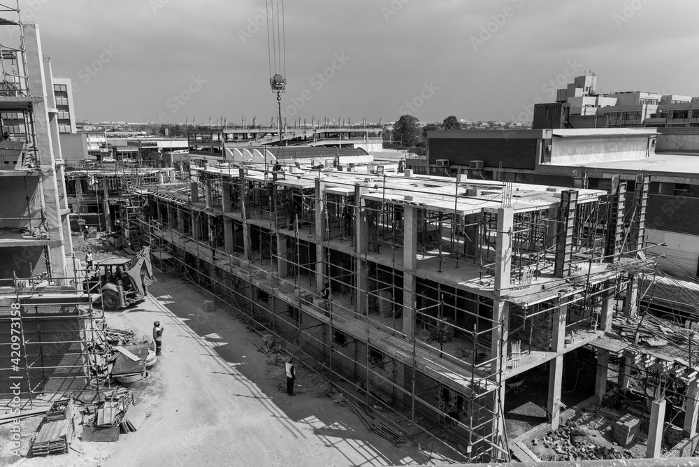 Construction site of multi-storey building with concrete slabs and columns. Men at work .