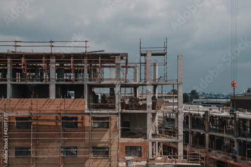 Construction site of multi-storey building with concrete slabs and columns. Men at work .