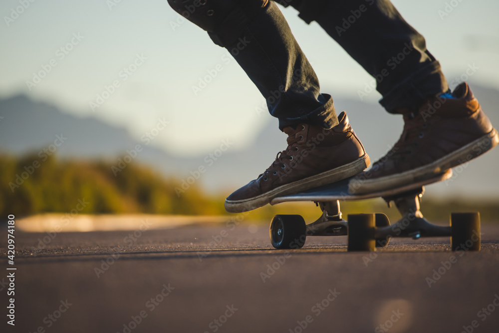 Skateboarder skateboarding on an open road doing freestyle tricks