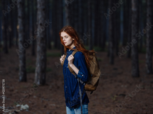 Woman Tourist with a backpack on her back walks on nature in the forest