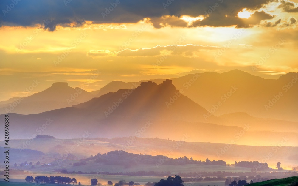 Obraz premium SPECTACULAR DRAKENSBERG SKIES. light refracts into yellow and blue along the egde of cloud bank. Drakensberg, South Africa