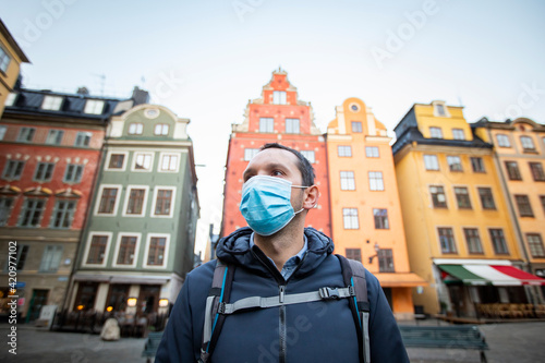 Photography Tourist in Stockholm wearing a medical mask while visiting the old town