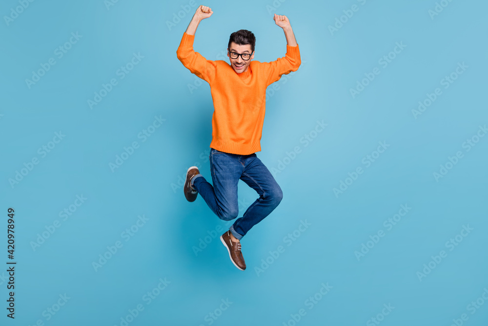 Full body photo of young excited man happy positive smile jump up rejoice victory isolated over blue color background
