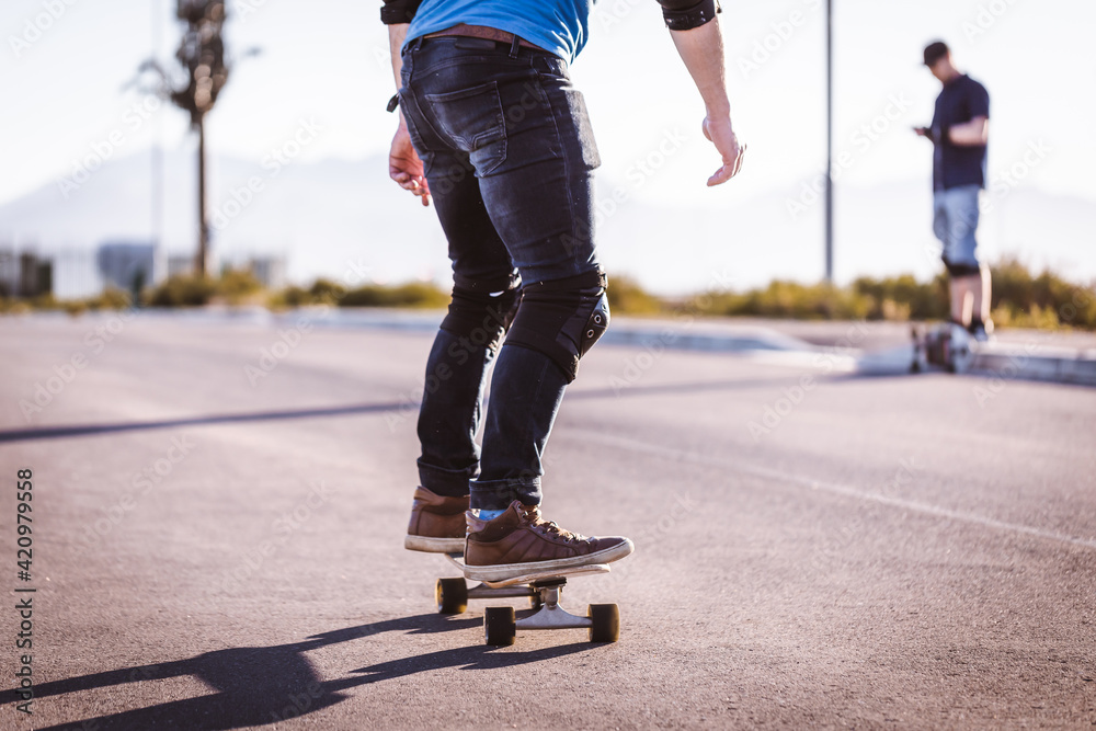 Skateboarder skateboarding on an open road doing freestyle tricks Skateboarder skateboarding on an open road doing freestyle tricks