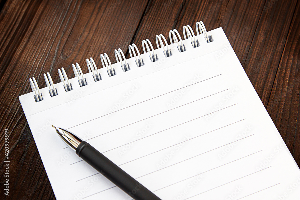 notepad and pen on a wooden background notepad and pen on a wooden background