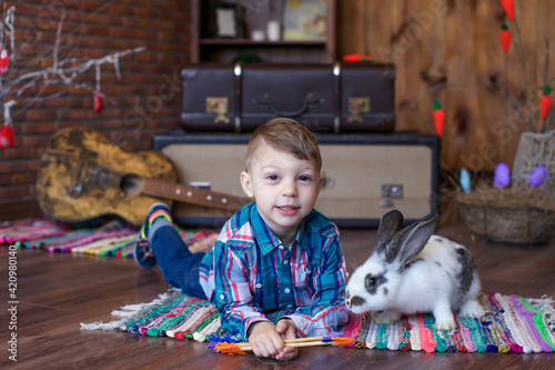 boy in a good mood plays with an Easter bunny, joy on the baby's face