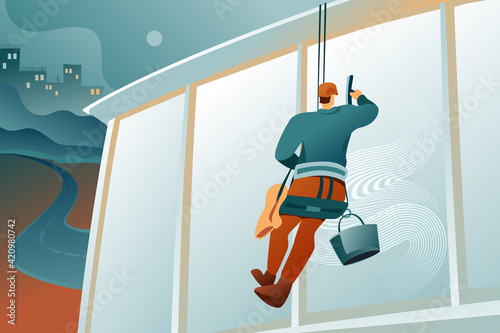 A male industrial climber washes the windows of a building with a safety rope. A guy in a helmet and a special uniform holds a brush for washing windows against the background of an abstract landscape