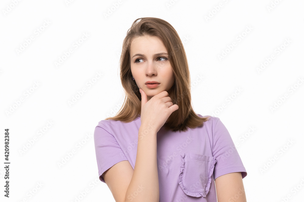 close up young pretty woman looking thinking with hand on chin, wondering or asking a question close up young pretty woman looking thinking with hand on chin, wondering or asking a question