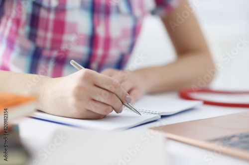 Woman hand makes notes with pen in notebook