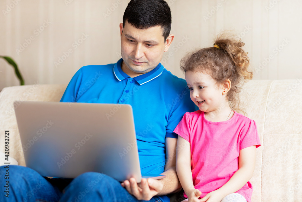 dad and daughter using laptop, watch cartoons educational online program, buying shopping via internet concept. man and girl communicating via Video call with grandparents, friends. dad and daughter using laptop, watch cartoons educational online program, buying shopping via internet concept. man and girl communicating via Video call with grandparents, friends.