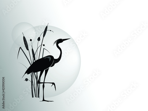 Fototapeta A silhouette of stand on one leg heron against the backdrop of a cattail bush and large sun circle