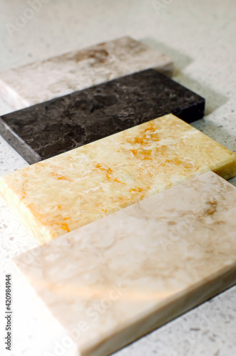 Samples of acrylic stone for kitchen countertops. Close-up, vertical photography.