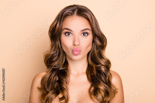 Portrait of nice long hairdo lady blow kiss without clothes isolated on pastel beige color background