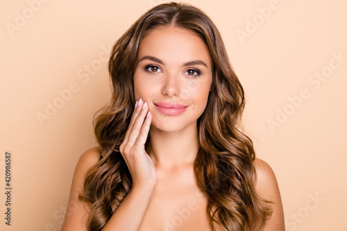 Photo of nice long hairdo optimistic lady without clothes apply cream isolated on pastel beige color background