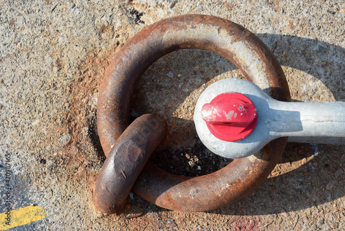 Anello piantato sul cemento legato a un grillo di metallo photo