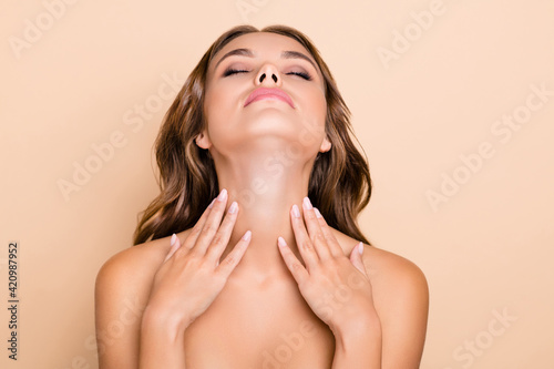 Photo of nice long hairdo optimistic lady without clothes hands neck closed eyes isolated on pastel beige color background