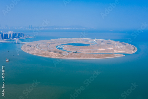 Aerial view of an artificial island on the sea against blue sky and ocean, the Double Happiness Island at the coastline between Xiamen and Zhangzhou in Fujian, China