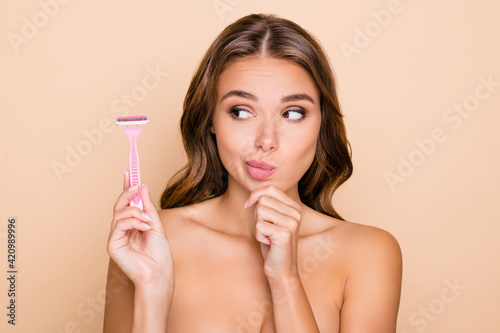 Fotografía Photo of young thoughtful minded woman hold finger chin look at razor epilation