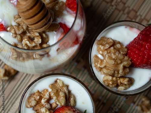 Natural and healthy dessert of yogurt, honey, strawberries and walnuts