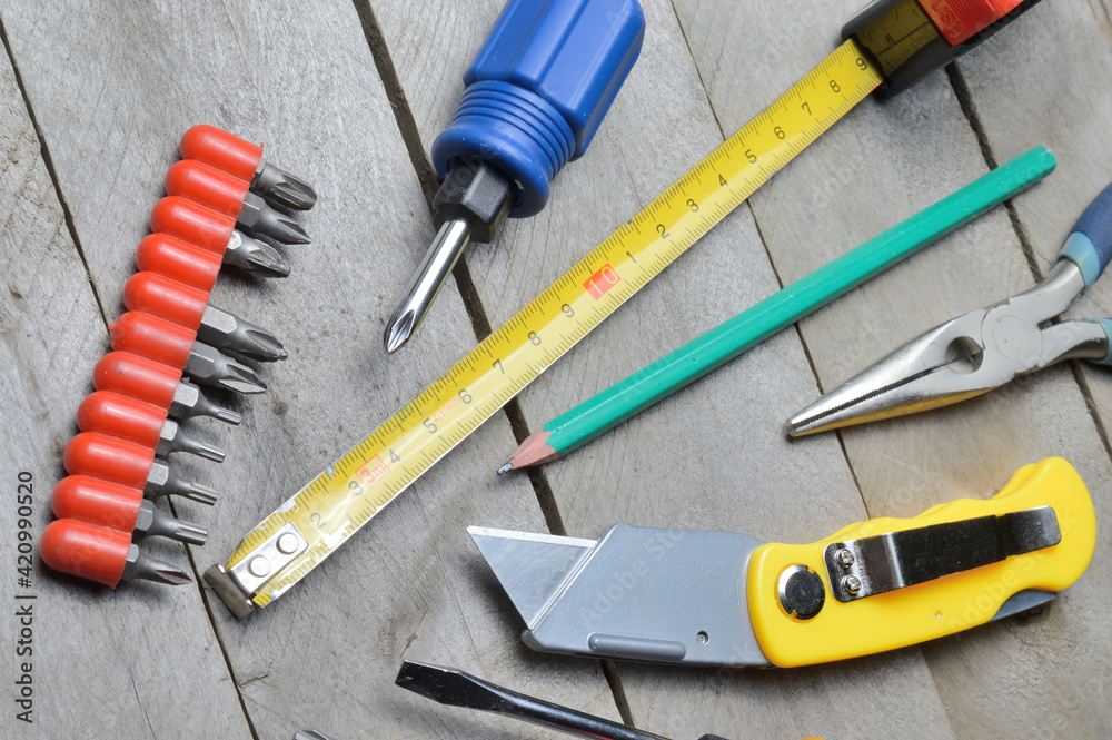 some home repair tools lie on a wooden background. close-up. some home repair tools lie on a wooden background. close-up.