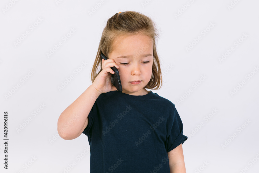 Little blonde girl talking on her mobile phone