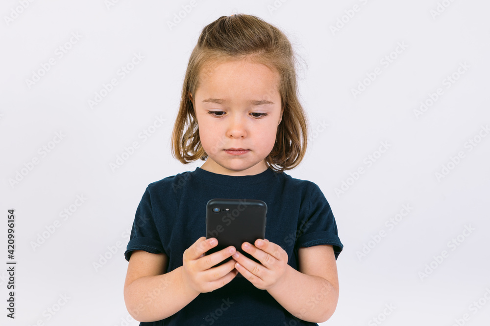 Little blonde girl looking at her mobile phone Little blonde girl looking at her mobile phone