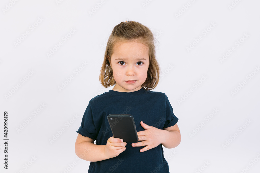 Little blonde girl with mobile phone in her hands, gesturing Little blonde girl with mobile phone in her hands, gesturing