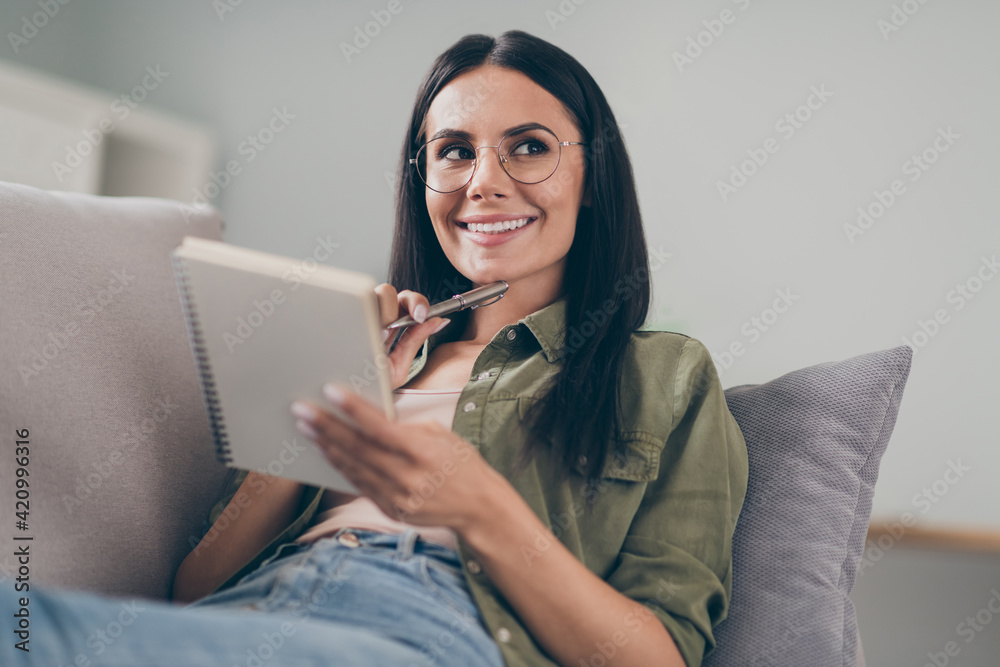 Close-up portrait of lovely cheerful girl lying on divan writing creating new story hobby at home house flat indoor Close-up portrait of lovely cheerful girl lying on divan writing creating new story hobby at home house flat indoor