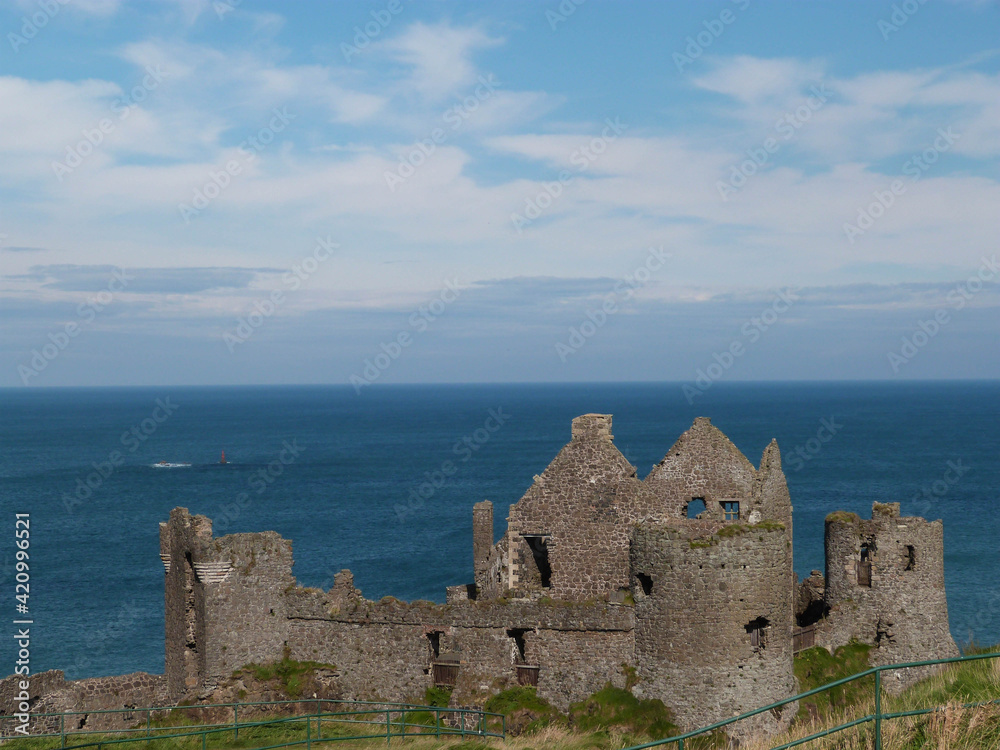 old irish ruin in front of the ocean with blue sky