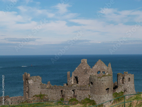 old irish ruin in front of the ocean with blue sky