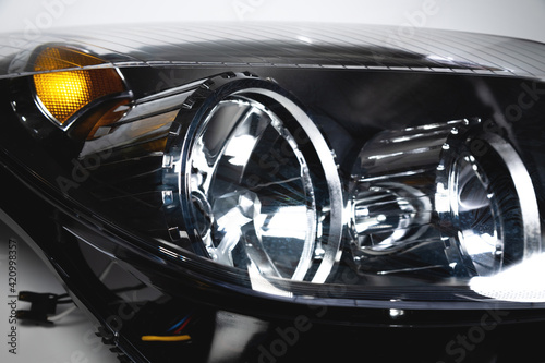 Close-up of a new headlight for a passenger car in soft focus. Auto lighting theme background © yanik88