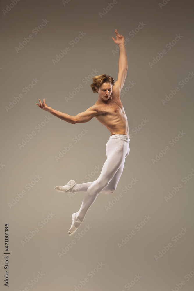 Foto Stock Aesthetic. Young and graceful ballet dancer isolated on studio  background in flight, jump. Art, motion, action, flexibility, inspiration  concept. Flexible caucasian ballet dancer, moves in glow. | Adobe Stock