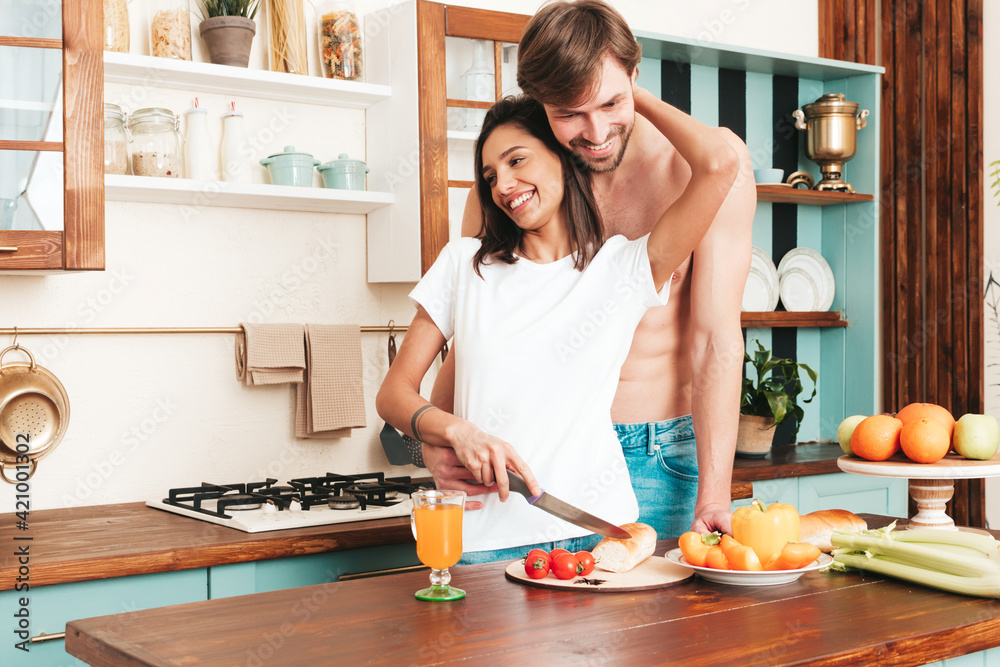 Smiling beautiful woman and her handsome boyfriend.Happy cheerful loving family having tender moments.Pure models making breakfast.Embracing each other.Cooking together in light kitchen at home Smiling beautiful woman and her handsome boyfriend.Happy cheerful loving family having tender moments.Pure models making breakfast.Embracing each other.Cooking together in light kitchen at home