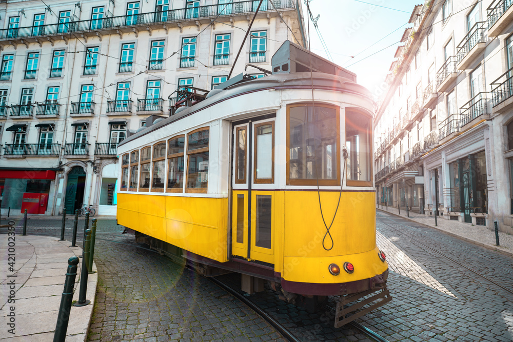 A famous yellow tram on a sunny summer day in Lisbon city old town, Portugal. Trams in Lisbon. Tourist attraction 
