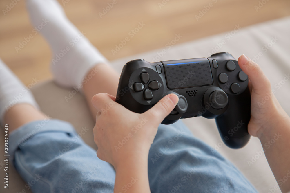 Close-up of a girl with joystick in hand, view from the back. A child plays video games. Leisure time at home. Close-up of a girl with joystick in hand, view from the back. A child plays video games. Leisure time at home.