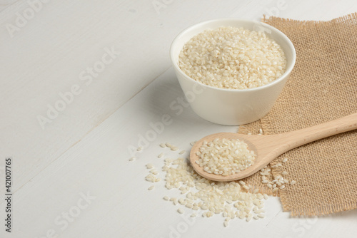 Arroz redondo en un bol blanco de cocina en la mesa blanca photo