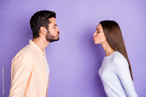 Profile side photo of man and woman air kiss each other boyfriend girlfriend date isolated on violet color background