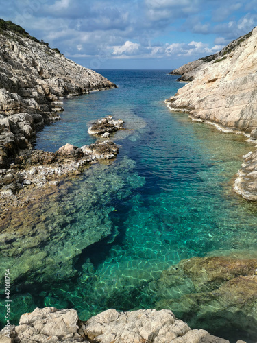 Colorful turquoise seawater seen from a cliff. Amazing colors in the sea.  Narrow sea gulf between limestone cliffs. 